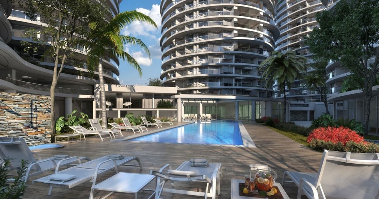 Exterior y piscina con reposeras en el edificio AVA La Caleta del estudio de arquitectos BMA