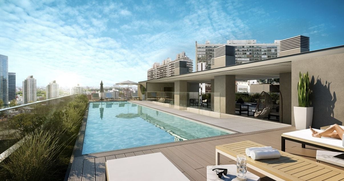 Piscina al aire libre con deck de madera y reposeras en el edificio More Echevarriarza de la desarrolladora inmobiliaria Altius Group