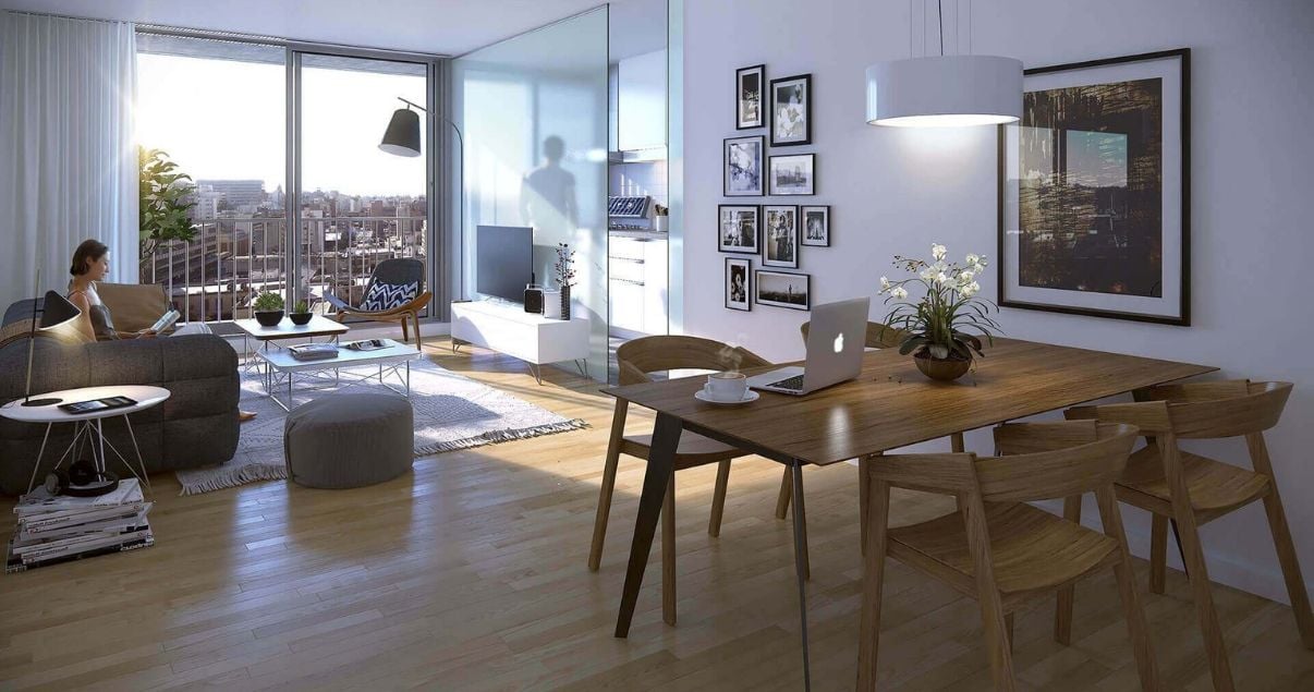 Living con mesa, sillas y ventanal luminoso de un apartamento en edificio Dómini Roxlo del estudio de arquitectos Pablo Szames